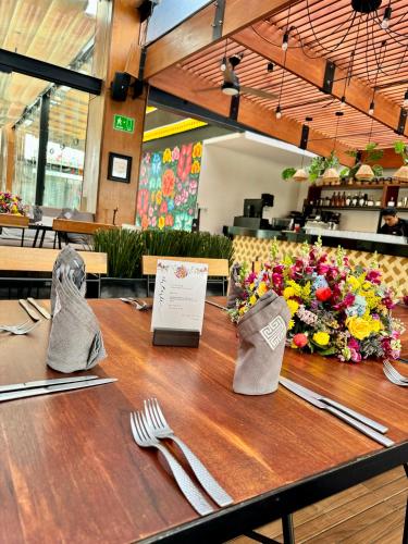 a table with forks and napkins and flowers on it at Casa de la Luz Hotel Boutique in Mexico City