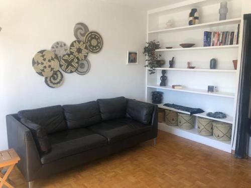 パリにあるParis center Apartment luxuryのリビングルーム(黒いソファ、白い棚付)