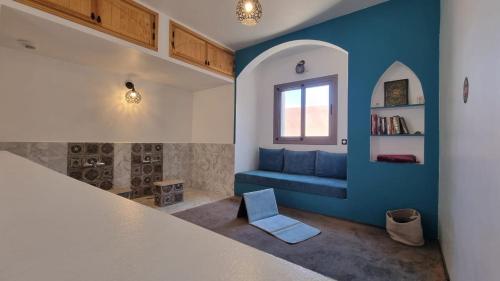 a living room with a blue couch and a window at Villa avec piscine Asilah, terrain de foot privative in Asilah