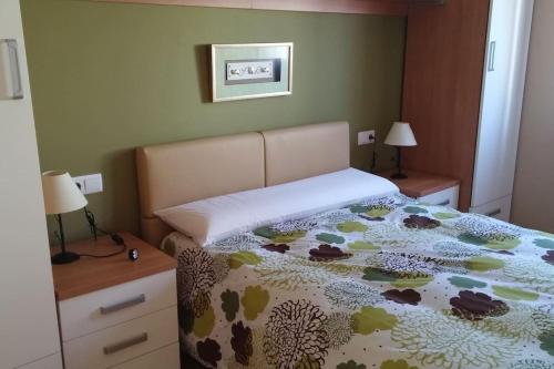 ein Schlafzimmer mit einem Bett mit Blumenbettdecke und zwei Lampen in der Unterkunft Casa da Ameixida in Ribeira