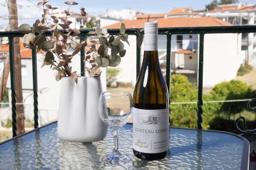 a bottle of wine and a glass on a table at Asterios Apartments in Polykhrono