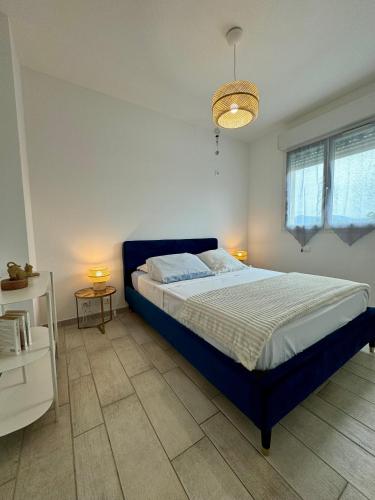 - une chambre avec un lit bleu et deux tables dans l'établissement Evasion de rêve à Casa Nina, à Borgo