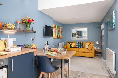 a kitchen and living room with blue walls at Fabulous apartment for 2 in Llansteffan in Llanstephan