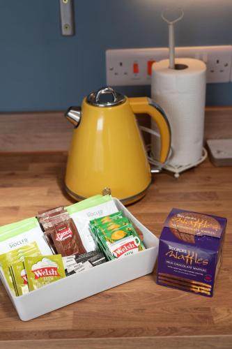 a table with a tea kettle and a box of food at Fabulous apartment for 2 in Llansteffan in Llanstephan