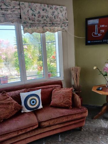 a couch in a living room with two windows at Armonia Studios in Anaxos