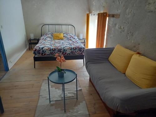 un salon avec un canapé et un lit dans l'établissement Chez Candice et Pascal gîte 1, à Lauraët