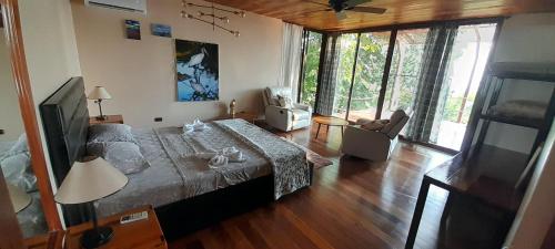 a bedroom with a large bed and a television at Corcovado Private Houses-Villas-Tents-Nature-Relaxing in Puerto Jiménez