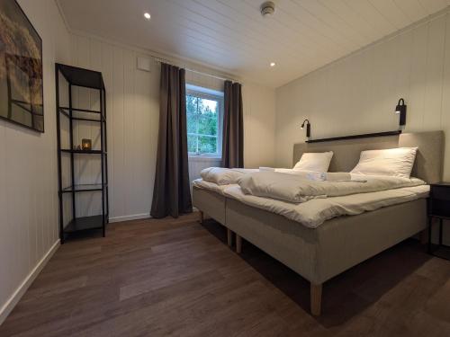 um quarto com uma cama grande e uma janela em Villa Fregn em Ljørdal