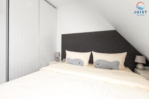 a bedroom with a white bed with two pillows at Haus Inselresidenz Strandburg Wohnung S305 in Juist