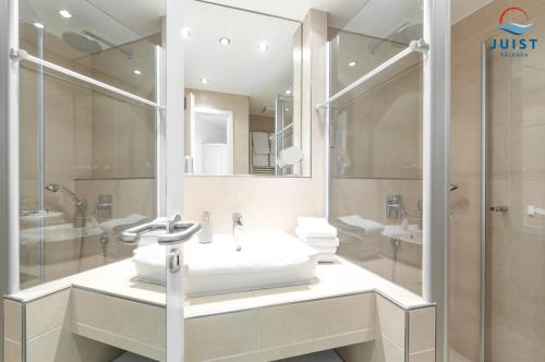a bathroom with a sink and a shower at Haus Inselresidenz Strandburg Wohnung S305 in Juist