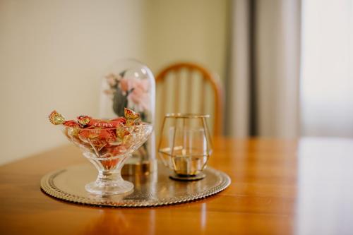 a table with a glass vase with flowers and a drink at Saules iela 2A in Saldus