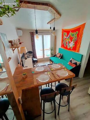 un salon avec une table et des chaises en bois dans l'établissement Superbe T2 atypique climatisé rdc à 2mn de la Plage, à Saint-Cyprien
