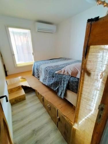 - une chambre avec un lit sur un cadre en bois dans l'établissement Superbe T2 atypique climatisé rdc à 2mn de la Plage, à Saint-Cyprien