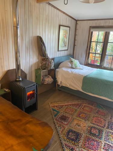 a bedroom with a bed and a wood stove at Departamento La Solar 1 ambiente in Frutillar