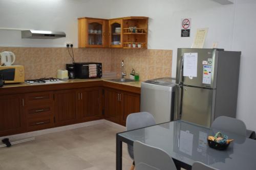 a kitchen with a table and a stainless steel refrigerator at Sea Front Apartment Villa in Flic-en-Flac