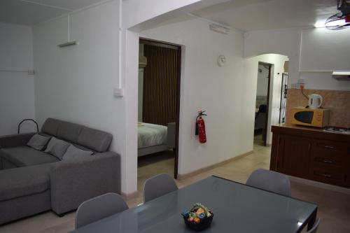 a living room with a couch and a table at Sea Front Apartment Villa in Flic-en-Flac