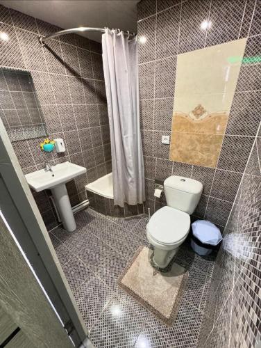 a bathroom with a toilet and a sink at Hotel GOLDEN DEGREZ in Bukhara