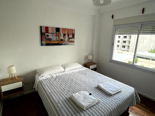 1 dormitorio con 1 cama con 2 toallas en Departamentos Alsina en Salta