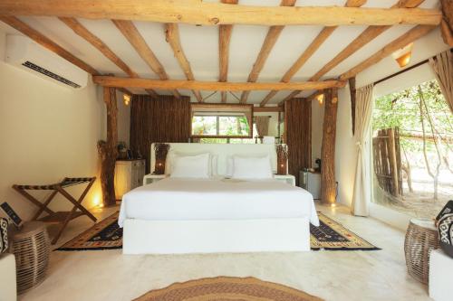 Una cama o camas en una habitación de Éteka Slow Beach Hotel Adults Only