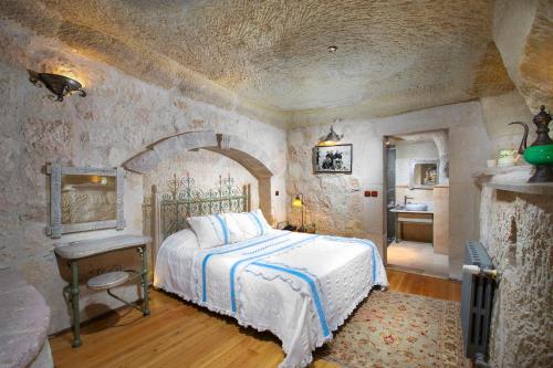 a bedroom with a bed and a table and a sink at Terra Cave Hotel in Goreme