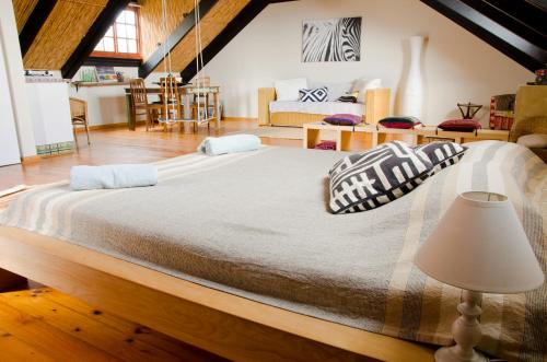Cama grande en habitación con lámpara en Sundowner Loft, en Mossel Bay