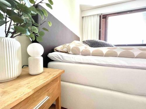a bedroom with a bed and a table and a window at Iso luksushuoneisto Forssan kattojen yllä in Forssa
