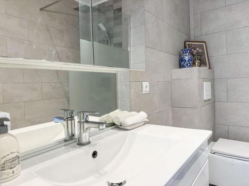 a white bathroom with a sink and a mirror at T3 Familial Pro Tarbes centre in Tarbes