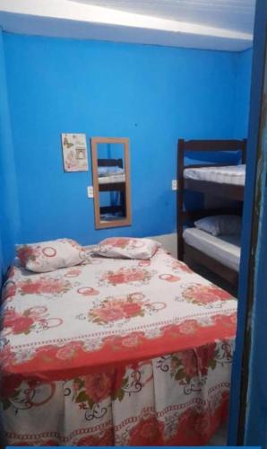 a blue bedroom with a bed with a red and white comforter at Pousada Terra do Sol in Fortaleza