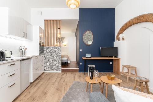 une cuisine avec des armoires blanches et un mur bleu dans l'établissement Le Rococo - Expérience léopard - Centre-ville, à Nantes