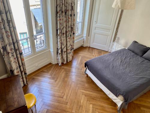 une chambre avec un lit et une grande fenêtre dans l'établissement Appartement de caractère 6 pers - hyper centre de Lyon, à Lyon