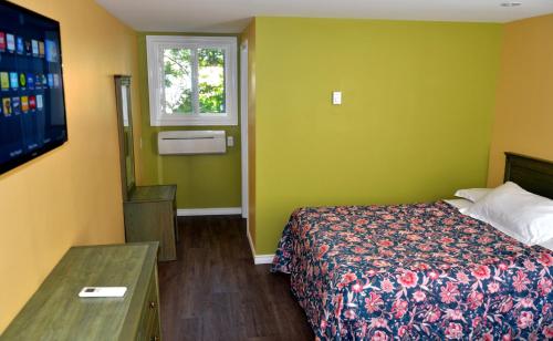 um quarto de hotel com uma cama e uma televisão em Meaford Inn em Meaford