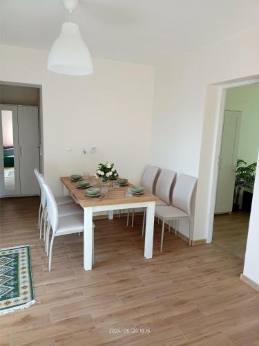 a dining room with a wooden table and white chairs at Gawlasoowka in Inwałd