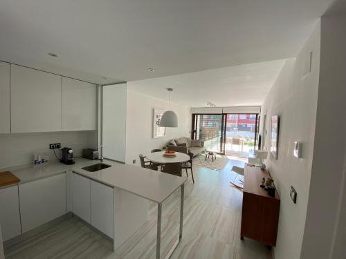 cocina y sala de estar con armarios blancos y mesa en Caballo de Mar, en Pilar de la Horadada