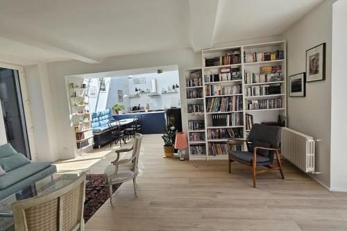 - un salon avec un canapé, des chaises et des étagères dans l'établissement Maison Almati près de l'île enchantée, à Fleury-sur-Orne