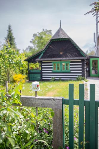a small house with a bird feeder on a fence at Chaloupka Křivoklát in Křivoklát