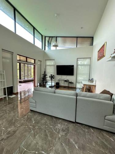a living room with a couch and a television at Mountain hills house poolvilla saraburi muaklek in Ban Sap Phrik