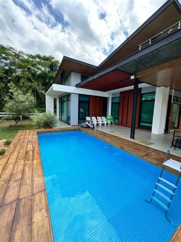 a large blue swimming pool in front of a house at Mountain hills house poolvilla saraburi muaklek in Ban Sap Phrik