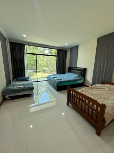 a bedroom with two beds and a window with a view at Mountain hills house poolvilla saraburi muaklek in Ban Sap Phrik