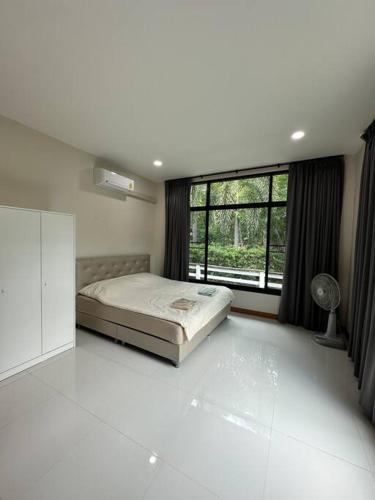a bedroom with a bed and a large window at Mountain hills house poolvilla saraburi muaklek in Ban Sap Phrik