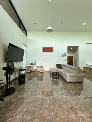 a living room with a couch and a flat screen tv at Mountain hills house poolvilla saraburi muaklek in Ban Sap Phrik