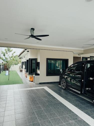 a car parked in front of a house with a ceiling fan at Rumah Tuma in Shah Alam