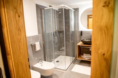 a bathroom with a shower and a toilet and a sink at Hotel Gruber in Sesto