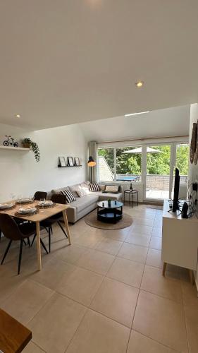 a living room with a couch and a table at Les Terrasses de Malmedy - duplex 430 in Malmedy