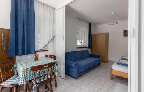 a living room with a blue couch and a table at Amazing Apartment In Omisalj in Omišalj