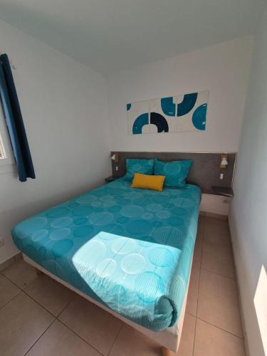 une chambre avec un lit avec une couette bleue dans l'établissement Lou Mas Azur, au Lavandou