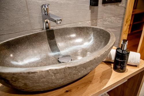 a sink in a bathroom with a bottle of soap at Hotel Gruber in Sesto