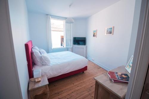 une petite chambre avec un lit et une fenêtre dans l'établissement CèdreBlanc, à Saint-Émilion