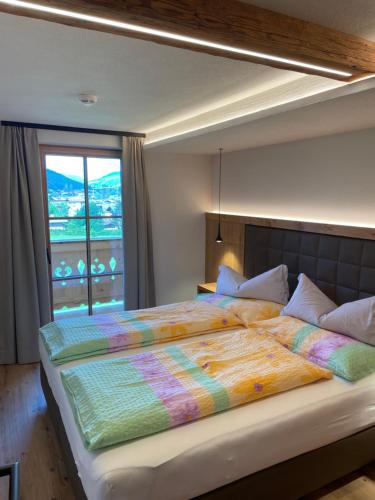 una camera da letto con un grande letto e una finestra di Wegrainhof a Kirchberg in Tirol