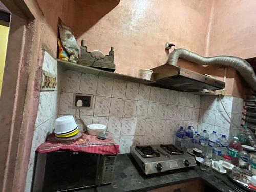 Una pequeña cocina con estufa y fregadero. en Thy Nest, en Calcuta