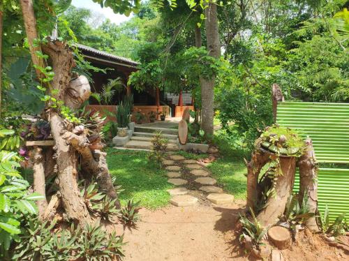 a garden with a path in front of a house at Jaana Guest in Sigiriya